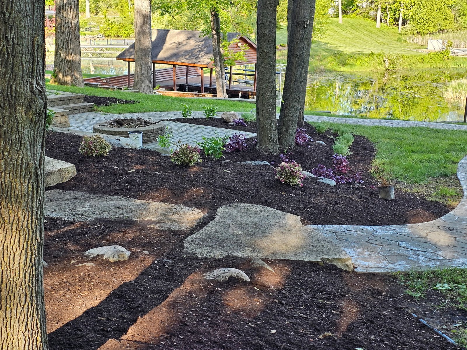 Fresh mulch installation around trees and shrubs by landscape contractor in Washington, MI